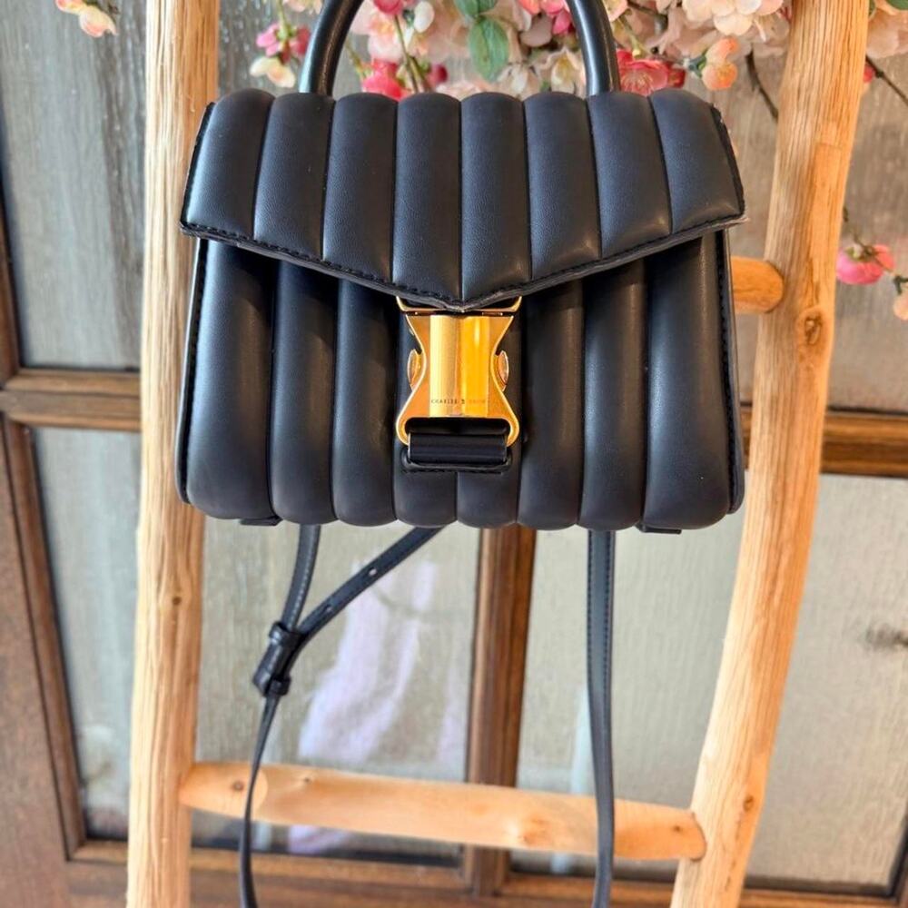 Charles and Kieth black bag with signs of consistent wear. Green curduroy bag